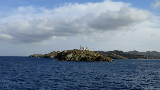 Greece, Kea Tzia island. Seascape with lighthouse, clear blue sky, view from a moving ship. 