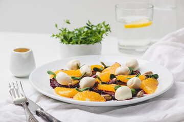 plate of salad with mozzarella, orange, caramelized beetroot, sprouted sunflower and pistachios