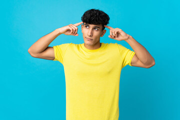 Young Argentinian man isolated on background having doubts and thinking