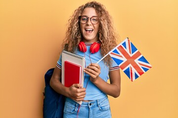 Beautiful caucasian teenager girl exchange student holding uk flag smiling and laughing hard out loud because funny crazy joke.