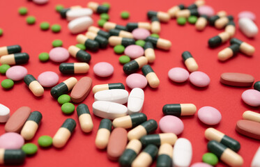 Pills capsules from diseases and viruses on a red background. Close-up.