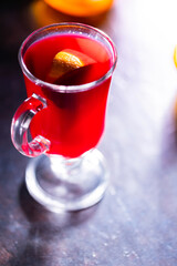 Christmas mulled wine on a dark background. Glass of mulled wine glows in the backlight. Traditional hot drink at Christmas time