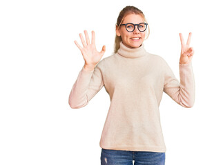 Young beautiful blonde woman wearing turtleneck sweater and glasses showing and pointing up with fingers number seven while smiling confident and happy.