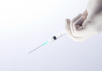 syringe in doctor's hand, white background