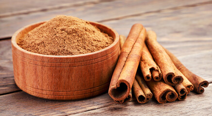 Cinnamon sticks and ground in a bowl on a wooden background. Cinnamon background