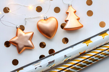 Christmas gold ornaments, star, Christmas tree, heart, wrapping paper, gold confetti on white background. Christmas composition