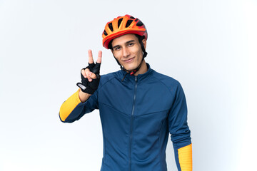 Young cyclist man isolated on background smiling and showing victory sign