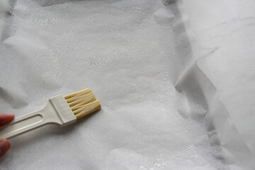 brushing oil onto white parchment paper 