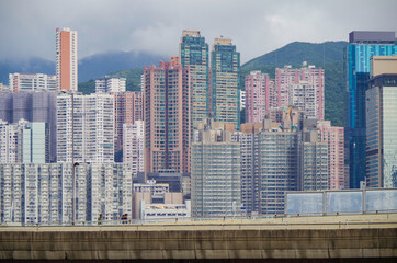 People on pedestrian bridge and panoramic view of Hongkong or Hong Kong skyline with modern and...