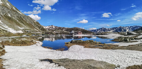 Ultra wide panorama of the lake in the Gotthardpass with snow - obrazy, fototapety, plakaty