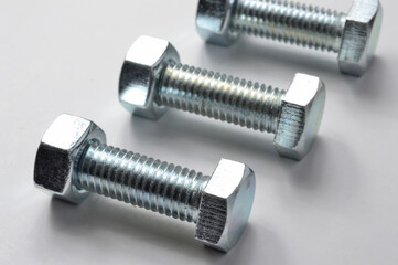 New chrome screw-nut of different sizes on a white background. Concept.