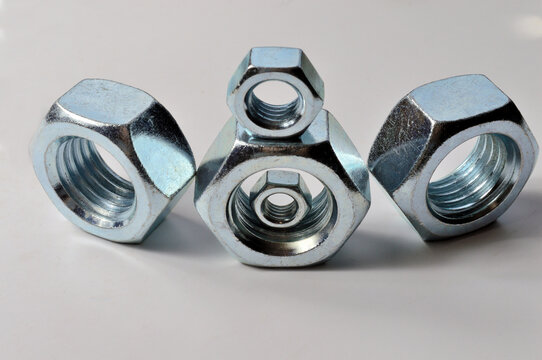 New chrome screw-nut of different sizes on a white background. Concept.