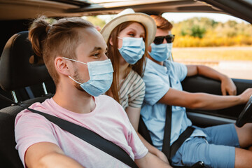 group of people riding in car with medical mask