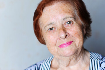 Obraz premium Smiling senior woman 70-80 year old posing over white background close up.Looking at camera. Wellness. Mature.