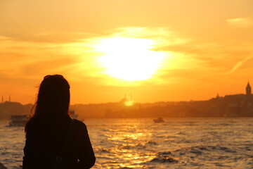 Fototapeta premium Silhouette of a woman looking to the Istanbul at sunset