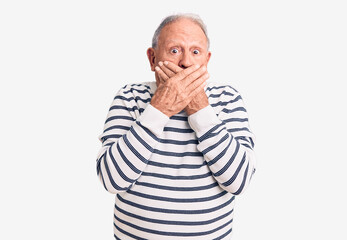 Fototapeta premium Senior handsome grey-haired man wearing casual striped sweater shocked covering mouth with hands for mistake. secret concept.