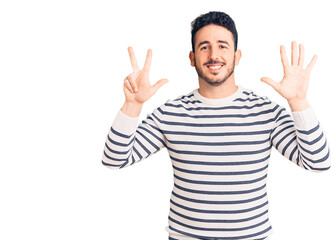 Young hispanic man wearing casual clothes showing and pointing up with fingers number eight while smiling confident and happy.