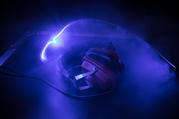 Dj music club concept. Close up headphones on dark background with colorful light.