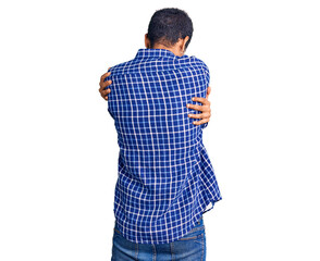 Fototapeta premium Young african amercian man wearing casual clothes hugging oneself happy and positive from backwards. self love and self care