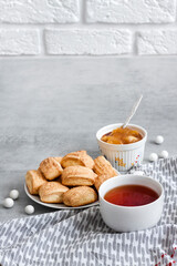 Tasty breakfast. Homemade sweet cinnamon cookies and cup of tea. Apple confiture on background