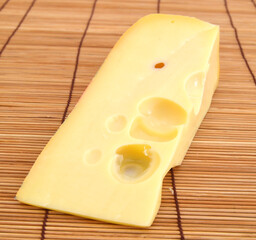 piece of cheese isolated on bamboo mat