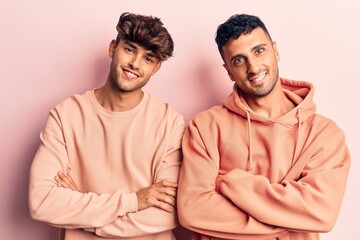 Young gay couple wearing casual clothes happy face smiling with crossed arms looking at the camera. positive person.