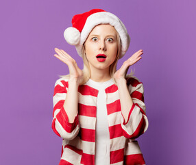 Beautiful blonde in Christmas hat on puprle background