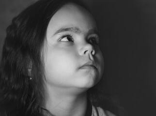 Little girl looks up black and white photo