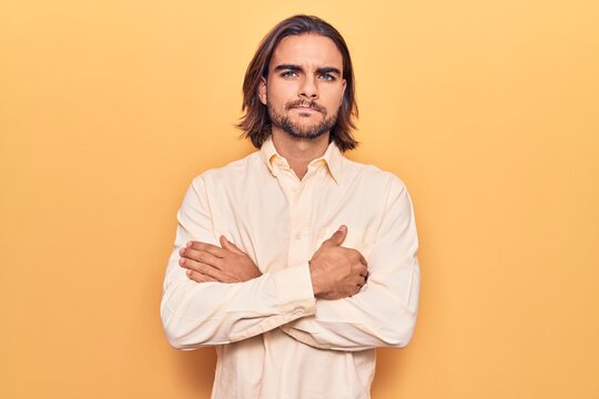 Young handsome man wearing business clothes skeptic and nervous, disapproving expression on face with crossed arms. negative person.