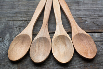 Four empty wooden spoons on a wooden table.