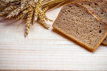 Rustic rye. Fresh loaf of rustic traditional bread with wheat grain ear or spike plant on wooden...