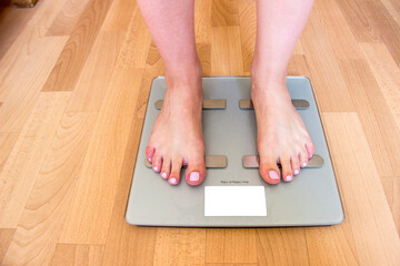 Beautiful well-groomed female legs stand on scales