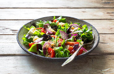 Fresh mix green leaves, tomatoes, soft cheese and walnuts salad