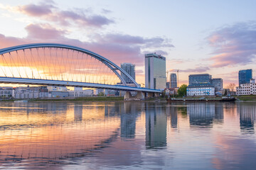 2020: Long exposure Apollo bridge over river Danube in Bratislava, Slovakia. Sunset, golden hour, dramatic skies. High rise buildings, travel destination