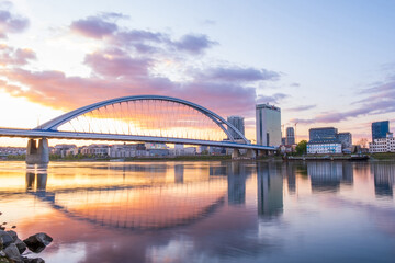 2020: Long exposure Apollo bridge over river Danube in Bratislava, Slovakia. Sunset, golden hour, dramatic skies. High rise buildings, travel destination