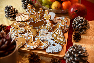 christmas cookies on the table with pine cones and fruits