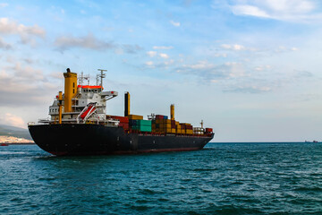 A large sea cargo ship (container ship) leaves the port. View from the stern of the departing container ship.