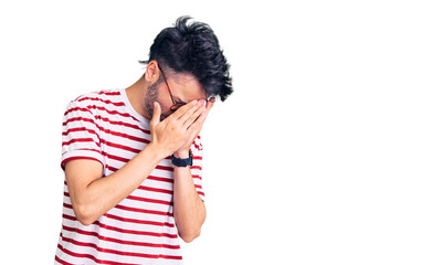 Young hispanic man wearing casual clothes with sad expression covering face with hands while crying. depression concept.
