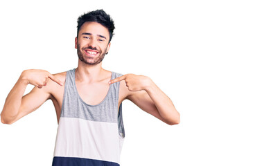 Young hispanic man wearing casual clothes looking confident with smile on face, pointing oneself...