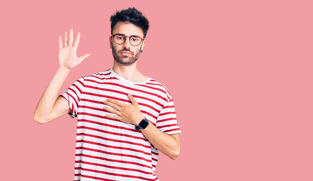 Young hispanic man wearing casual clothes swearing with hand on chest and open palm, making a loyalty promise oath