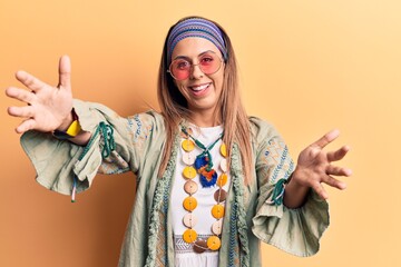 Young beautiful woman wearing hippi clothes looking at the camera smiling with open arms for hug. cheerful expression embracing happiness.