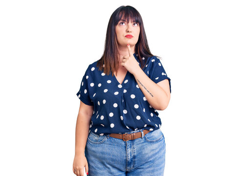 Young plus size woman wearing casual clothes thinking concentrated about doubt with finger on chin and looking up wondering