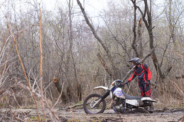 Motorbike racer with his vehicle stuck in mud