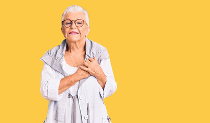 Senior beautiful woman with blue eyes and grey hair wearing casual clothes and glasses smiling with hands on chest with closed eyes and grateful gesture on face. health concept.