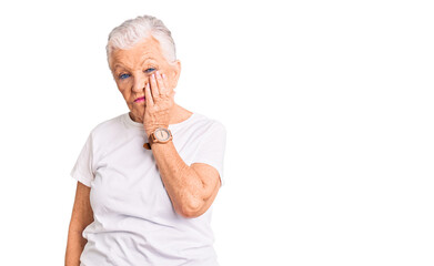 Senior beautiful woman with blue eyes and grey hair wearing casual white tshirt thinking looking tired and bored with depression problems with crossed arms.