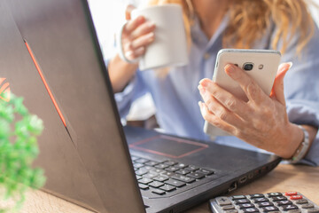 close-up of business woman hands with mobile phone and computer