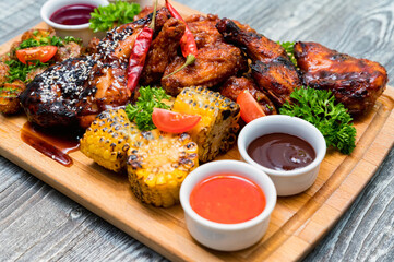Barbecue chicken with vegetables on wooden table