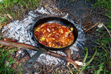 Cooking Dinner on campfire in cast iron pan. bbq photo
