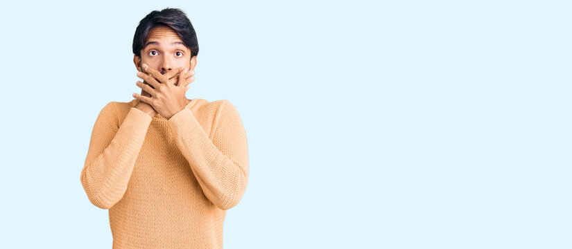 Handsome hispanic man wearing casual sweater shocked covering mouth with hands for mistake. secret concept.