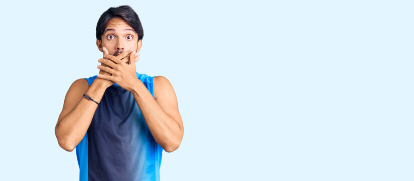 Handsome hispanic man wearing sportswear shocked covering mouth with hands for mistake. secret concept.